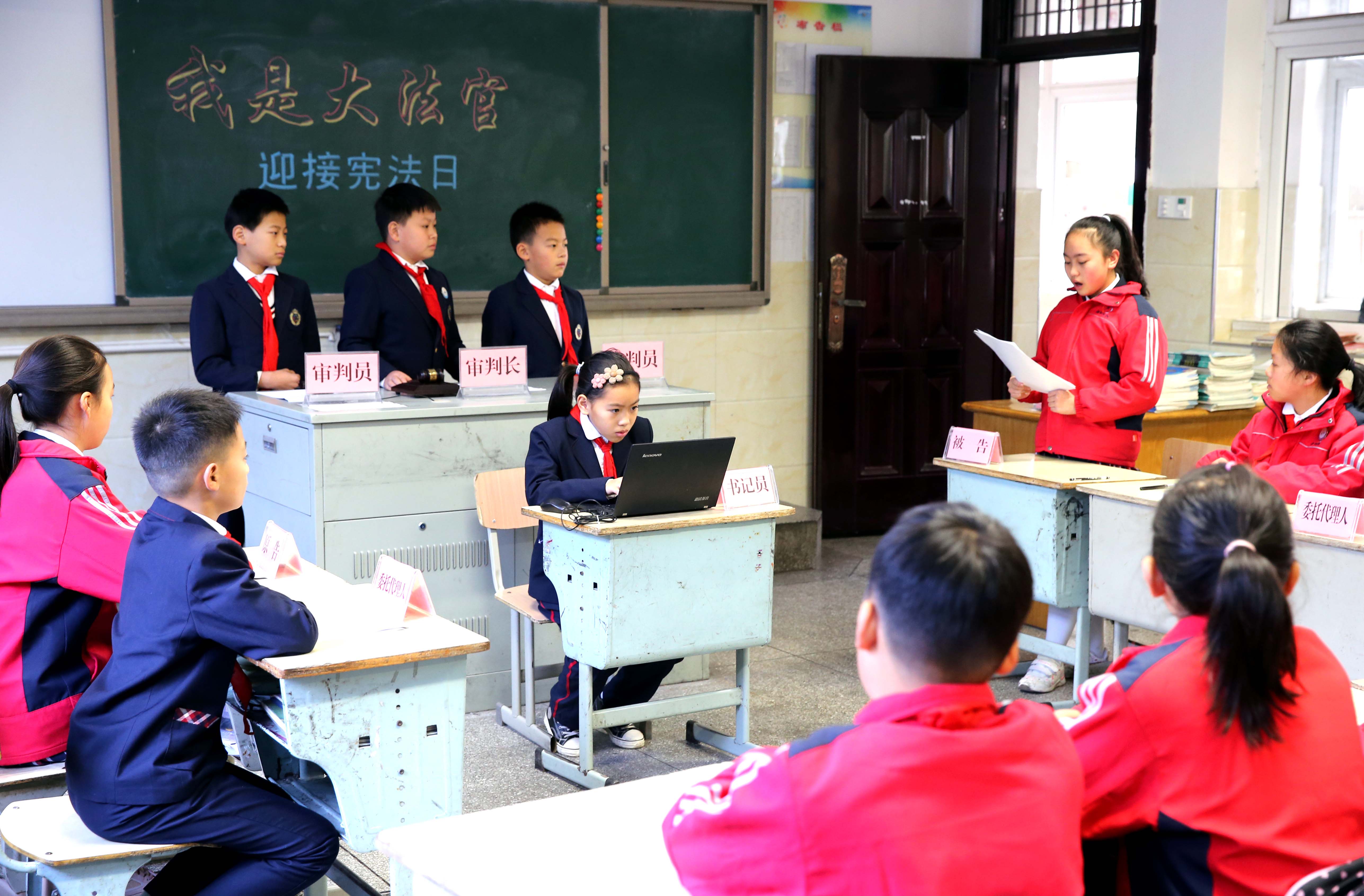 △2020年12月1日,浙江省德清县乾元镇中心小学,学生们在“模拟法庭”上进行“庭审”。