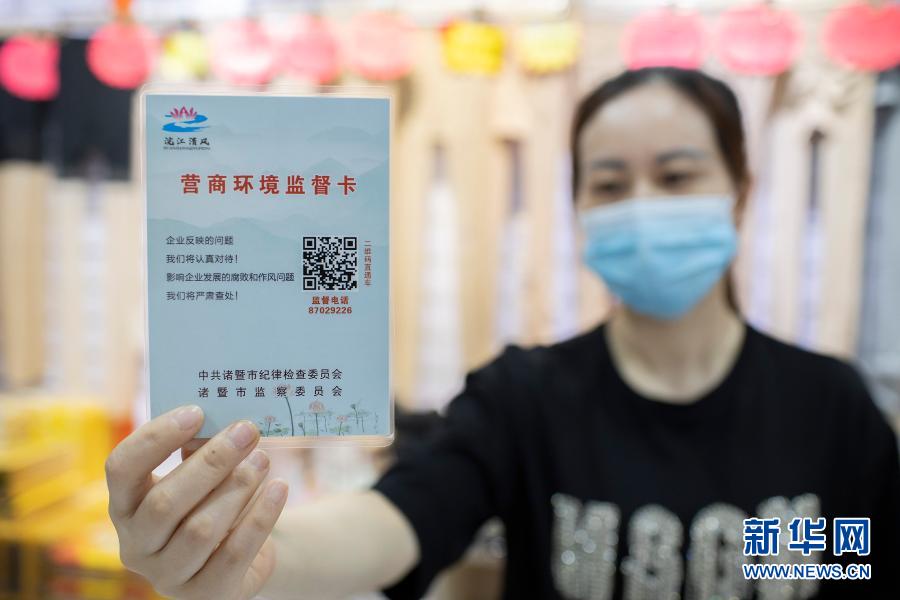 5月12日,浙江诸暨市一经营户在展示“营商环境监督卡”。诸暨市推出“营商环境监督卡”,助力复工复产,服务保障经济稳健发展。新华社发(郭斌 摄)