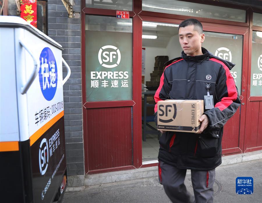 北京前门石头胡同快递站点“快递小哥”刘阔在整理包裹(2019年2月1日摄)。新华社记者 李德欣 摄